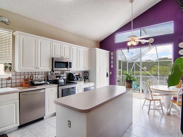 kitchen with ceiling fan, light tile floors, appliances with stainless steel finishes, and tasteful backsplash