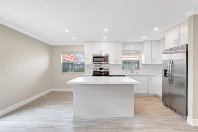 kitchen with stainless steel appliances, white cabinets, and a wealth of natural light