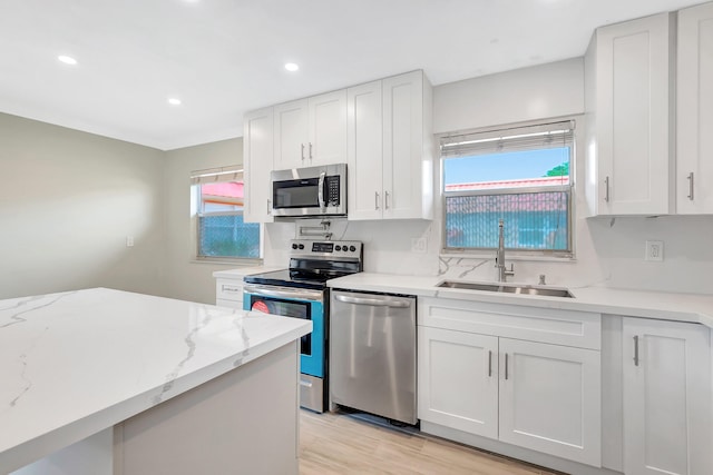 kitchen featuring white cabinets, a healthy amount of sunlight, stainless steel appliances, and sink