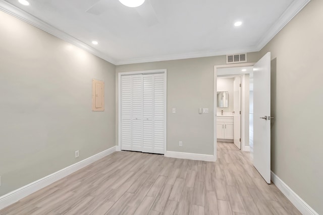 unfurnished bedroom featuring a closet, light hardwood / wood-style floors, ceiling fan, and ornamental molding