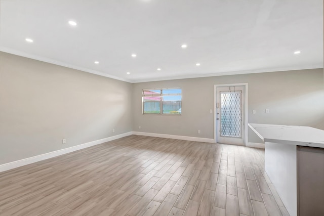 empty room featuring light hardwood / wood-style floors and ornamental molding