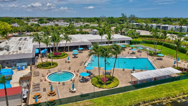 view of swimming pool featuring a lawn, a patio, and a hot tub