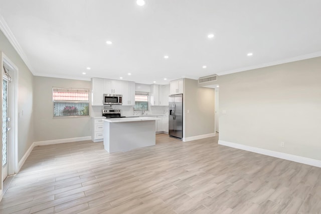 kitchen with white cabinets, light hardwood / wood-style floors, a center island, and appliances with stainless steel finishes