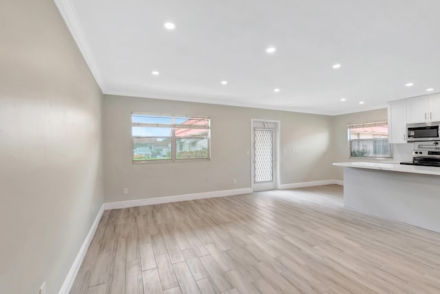 interior space with crown molding, a wealth of natural light, and light wood-type flooring