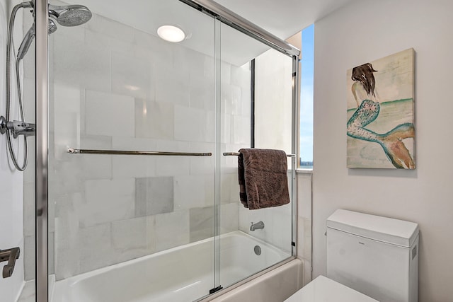 bathroom featuring toilet and combined bath / shower with glass door