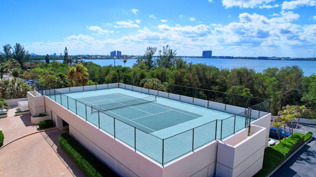 view of tennis court featuring a water view