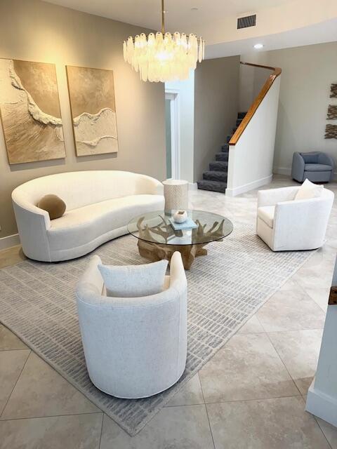 5250 N Ocean Dr Phn, Phn, Singer Island, FL 33404 - living room featuring stairs, a chandelier, baseboards, and tile patterned flooring