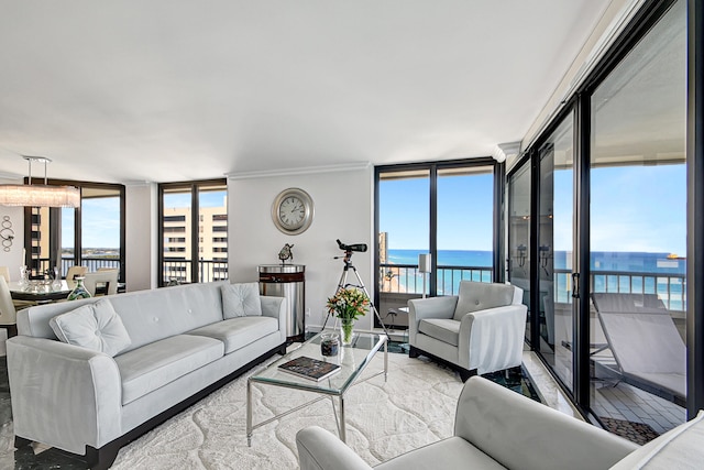 living room with plenty of natural light, a water view, and a wall of windows