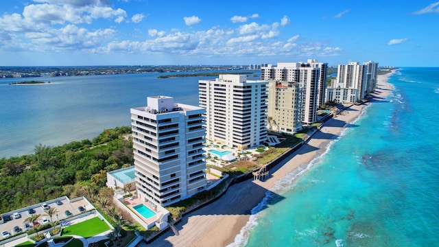 birds eye view of property with a water view and a beach view