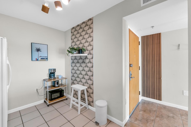 misc room featuring ceiling fan and light tile floors