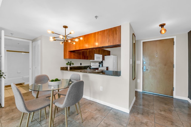 kitchen with white appliances, sink, hanging light fixtures, light tile flooring, and a notable chandelier