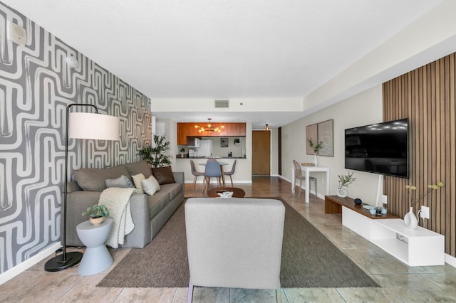 tiled living room with a notable chandelier