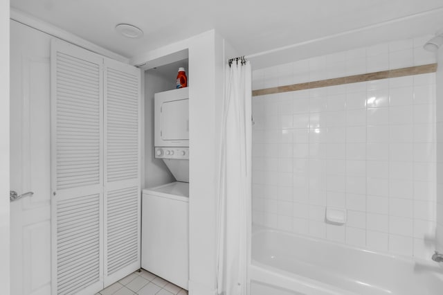 bathroom featuring tile floors, stacked washing maching and dryer, and shower / tub combo with curtain