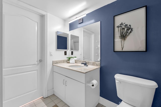 bathroom with toilet, tile flooring, and vanity