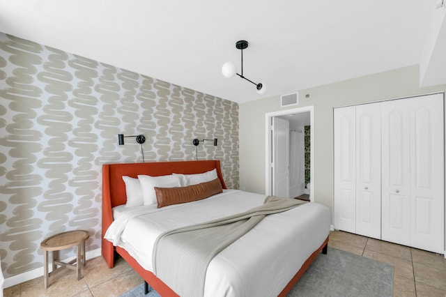 bedroom with a closet and light tile flooring