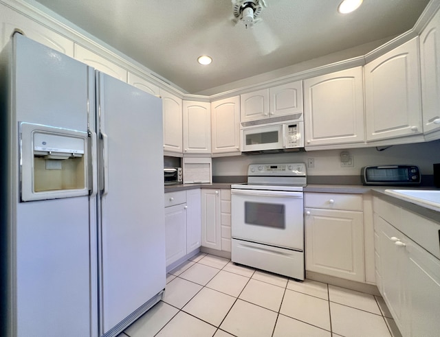 kitchen featuring white cabinets, white appliances, and light tile patterned flooring