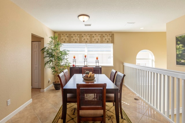 dining room featuring light tile floors and a textured ceiling