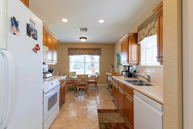 kitchen featuring white appliances, backsplash, sink, and light tile floors