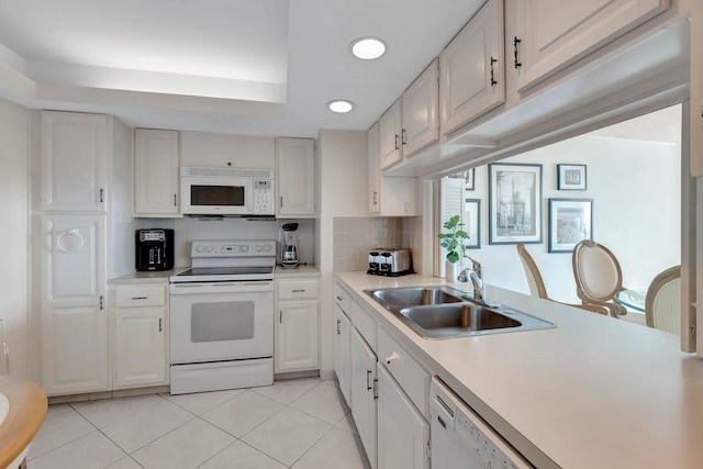 kitchen with white appliances, sink, light tile floors, tasteful backsplash, and white cabinetry