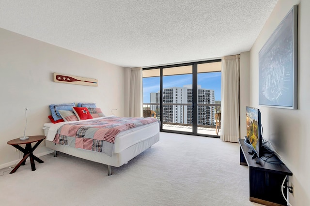 bedroom with light carpet, a textured ceiling, a wall of windows, and access to outside