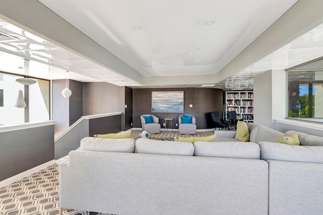 living room featuring a raised ceiling and tile floors