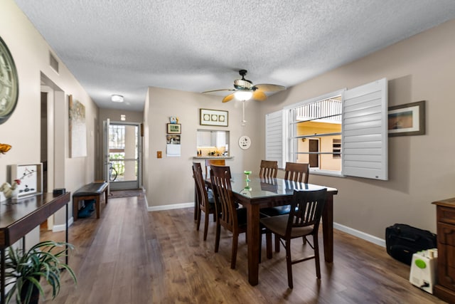 dining space with a textured ceiling, ceiling fan, and dark hardwood / wood-style flooring