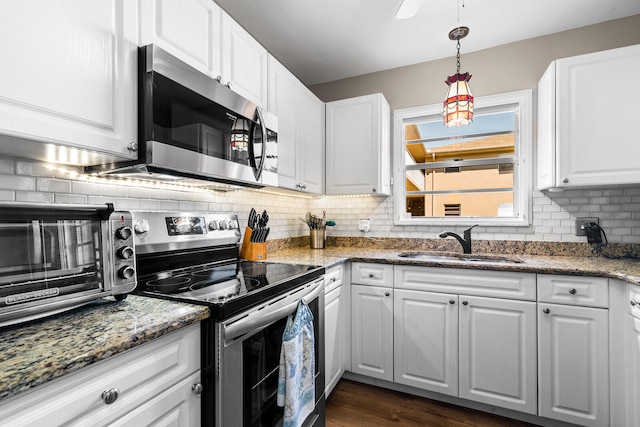 kitchen featuring appliances with stainless steel finishes, white cabinets, sink, and backsplash