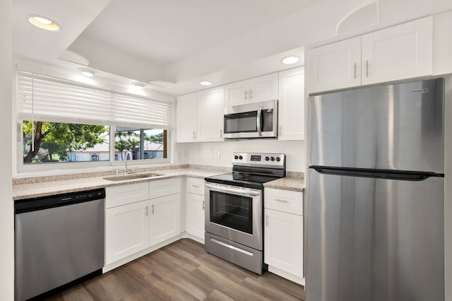 kitchen with dark wood-style floors, recessed lighting, appliances with stainless steel finishes, white cabinets, and a sink