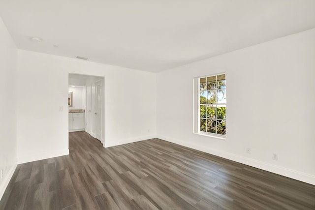 empty room with dark hardwood / wood-style flooring