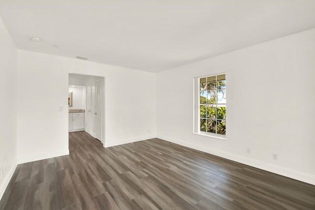 unfurnished living room with a chandelier and dark hardwood / wood-style flooring