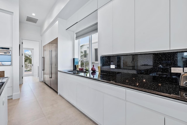 kitchen featuring visible vents, appliances with stainless steel finishes, a sink, and white cabinetry