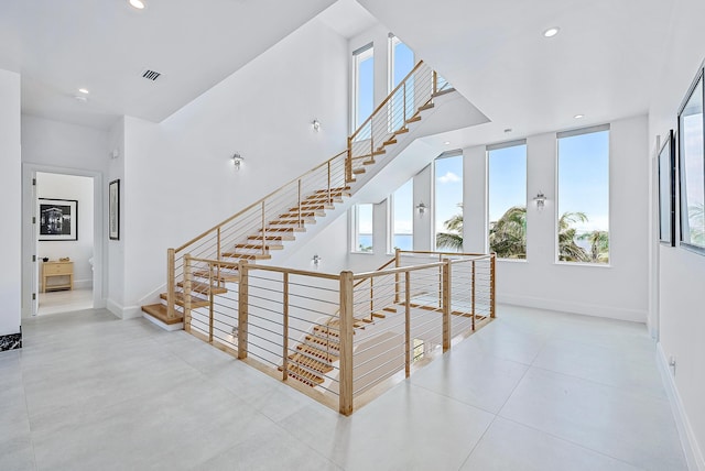 stairs featuring visible vents, baseboards, tile patterned flooring, and recessed lighting