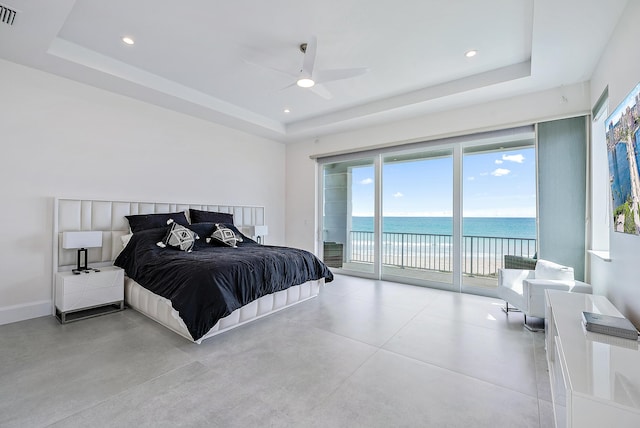 bedroom with a raised ceiling, visible vents, a water view, access to outside, and baseboards