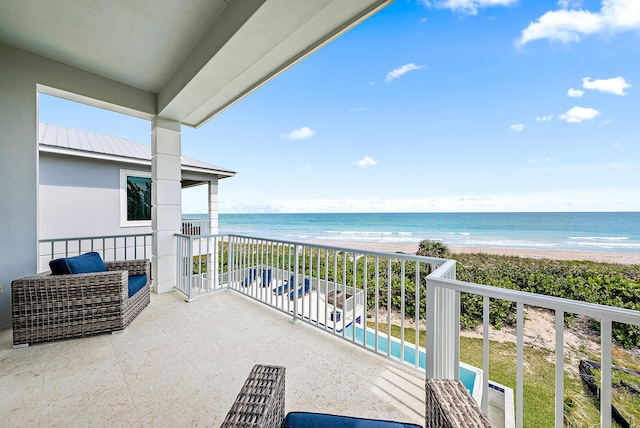 balcony featuring a water view and a view of the beach