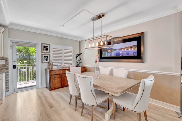 dining room with ornamental molding, light hardwood / wood-style floors, and an inviting chandelier