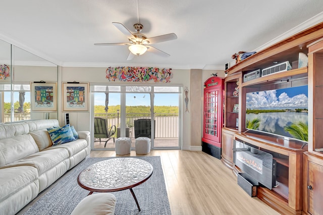 living room with a water view, ornamental molding, ceiling fan, and light wood-type flooring