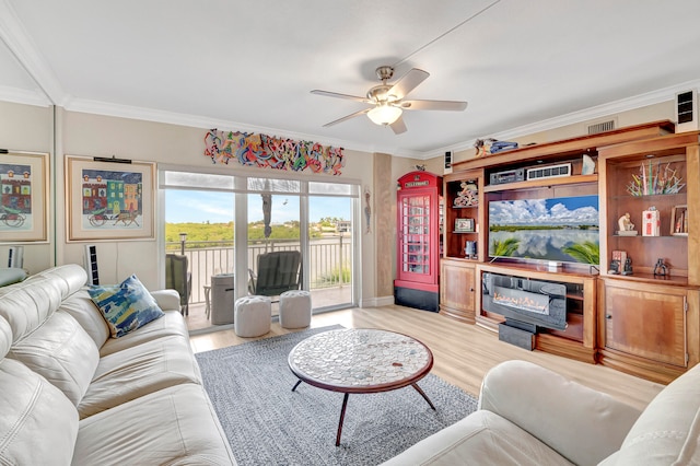 living room with ornamental molding, ceiling fan, and light wood-type flooring