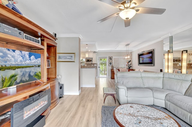 living room featuring ornamental molding, ceiling fan, and light wood-type flooring