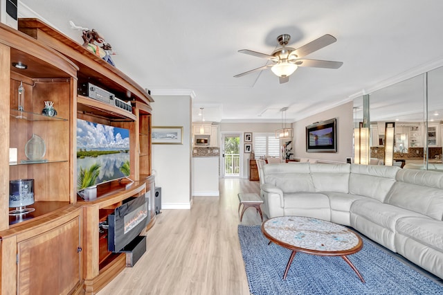 living room featuring light hardwood / wood-style floors, ceiling fan, and crown molding