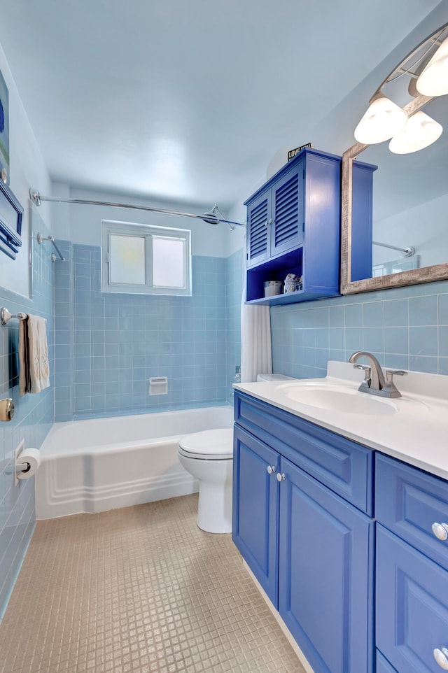 full bathroom featuring tiled shower / bath combo, tile flooring, toilet, and tile walls