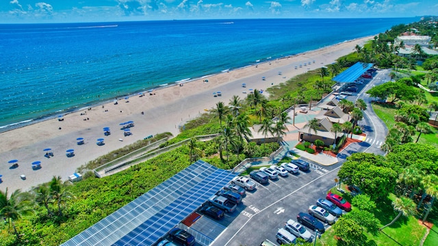 birds eye view of property with a water view and a beach view