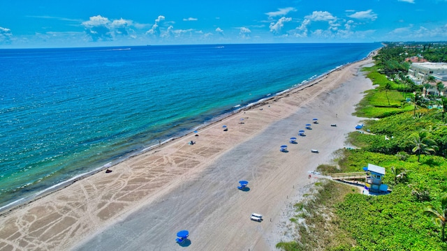 drone / aerial view with a water view and a beach view