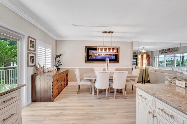 dining room with plenty of natural light, ornamental molding, ceiling fan, and light wood-type flooring