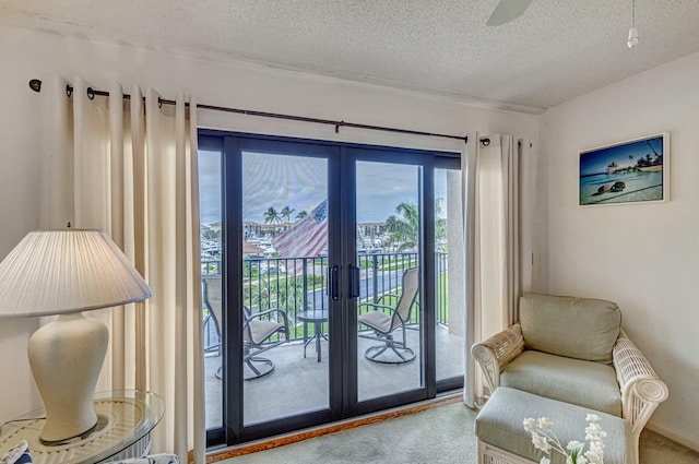 doorway to outside featuring light carpet, a healthy amount of sunlight, and a textured ceiling