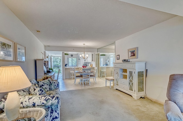 carpeted living room with an inviting chandelier