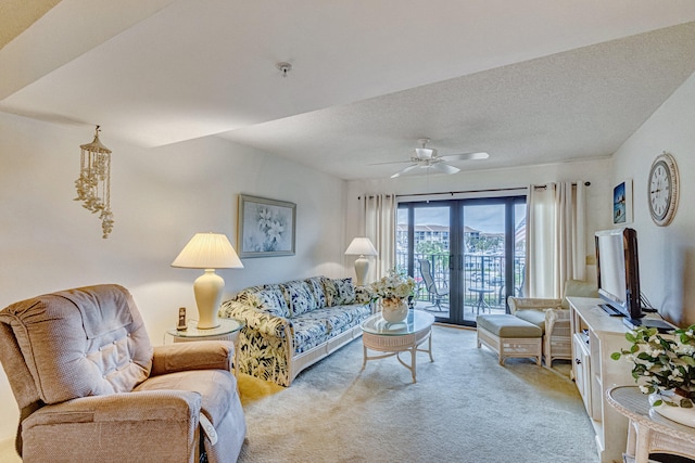 carpeted living room with french doors, ceiling fan, and a textured ceiling