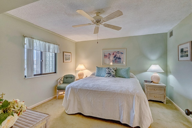 bedroom with a textured ceiling, ceiling fan, and light carpet