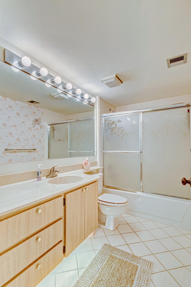 full bathroom featuring toilet, bath / shower combo with glass door, vanity, and tile flooring