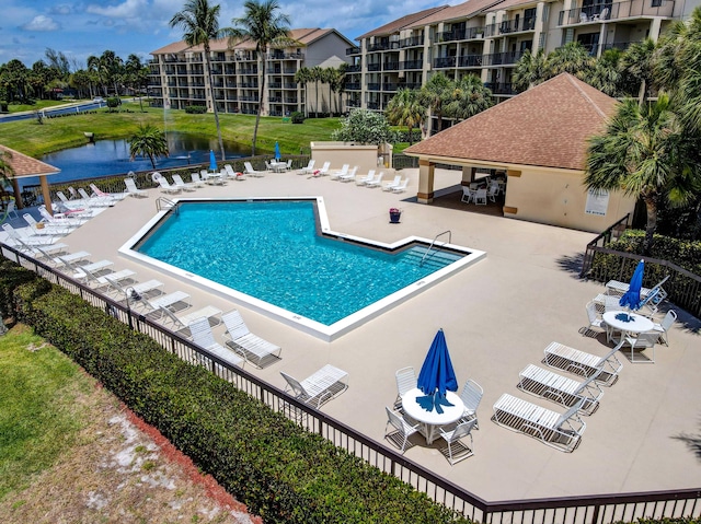 view of swimming pool with a patio, a yard, and a water view