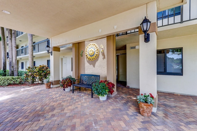 view of exterior entry with a balcony